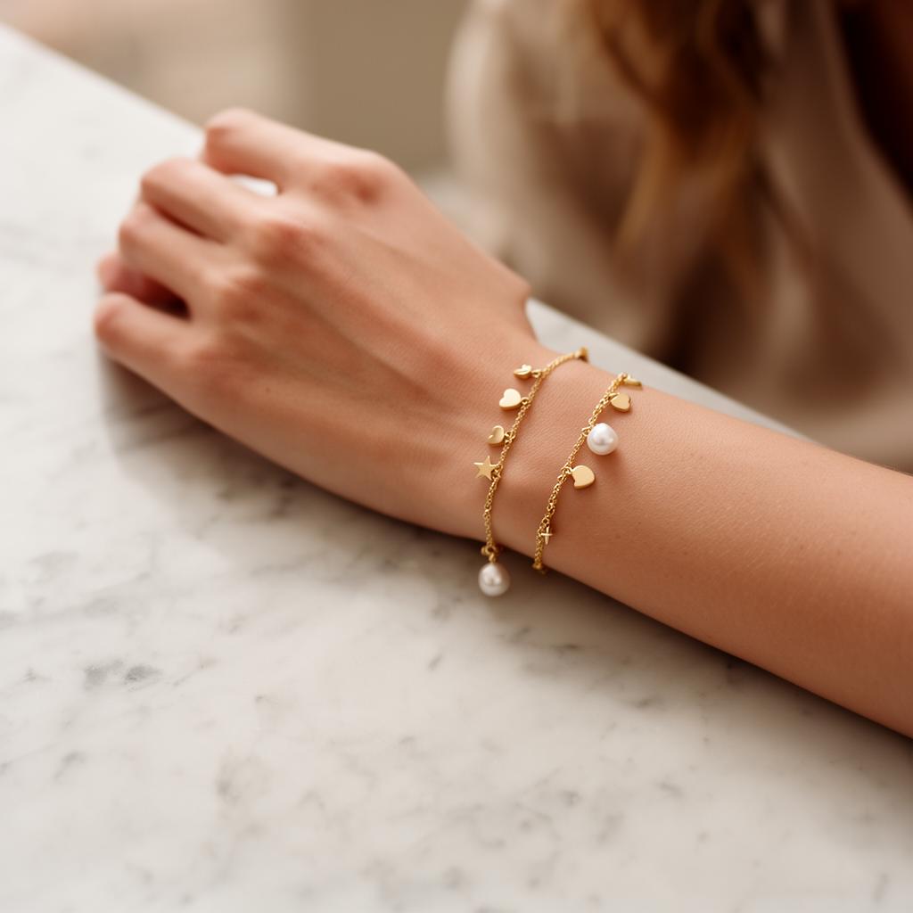 Delicate gold charm bracelet on a wrist